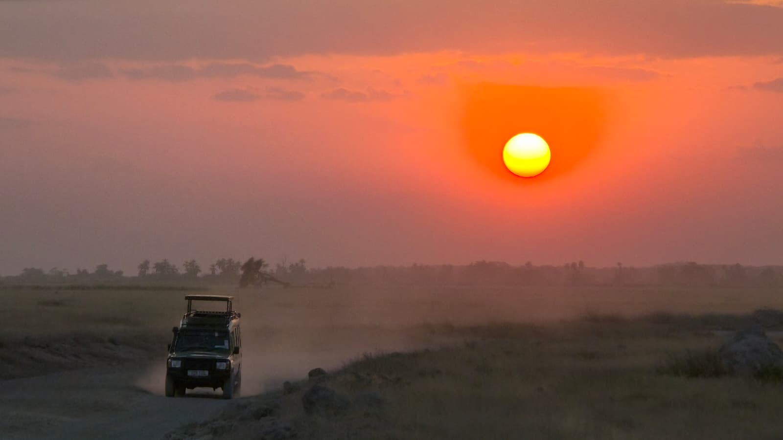 Jeep in viaggio nella savana al tramonto